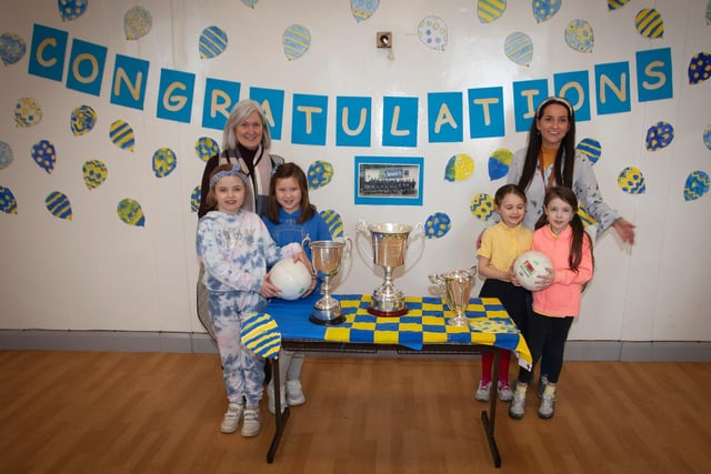 Some of the Primary 3 girls admiring the Derry, Ulster and All Ireland Championship winning trophies with Miss Lynch and Mrs Hutton at Steelstown Primary School. (Photo: Jim McCafferty)