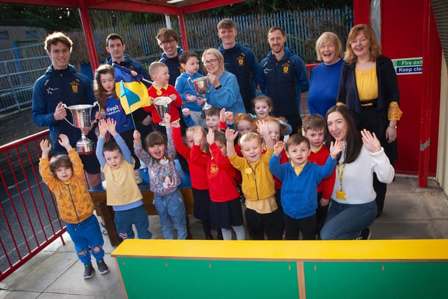 Steelstown Nursery children and staff give the All Ireland winning Steelstown Brian Og players a hearty welcome to the school. (Photo: Jim Cafferty)