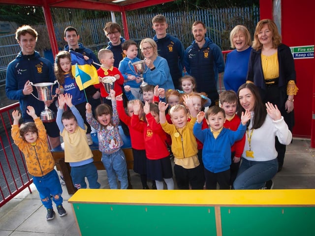 Steelstown Nursery children and staff give the All Ireland winning Steelstown Brian Og players a hearty welcome to the school. (Photo: Jim Cafferty)
