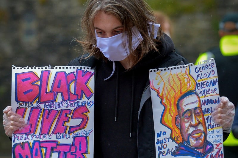 Woman with a posters at the Justice for George Floyd rally held in Guildhall Square on Saturday afternoon last. DER2320GS – 019