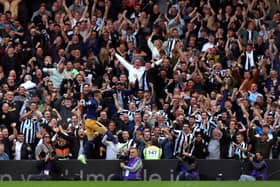 Newcastle United fans celebrate Miguel Almiron's second goal at Craven Cottage.