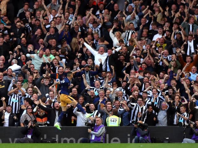 Newcastle United fans celebrate Miguel Almiron's second goal at Craven Cottage.
