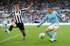 Phil Foden of Manchester City attempts to cross the ball past Emil Krafth of Newcastle United during the Premier League match between Newcastle United and Manchester City at St. James Park on August 21, 2022 in Newcastle upon Tyne, England. (Photo by Clive Brunskill/Getty Images)