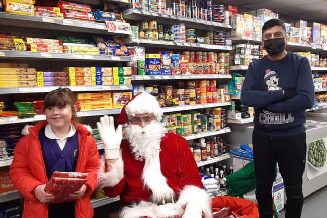 Nico Ali and Santa Claus (centre) have been helping bring the smiles to youngsters' faces.