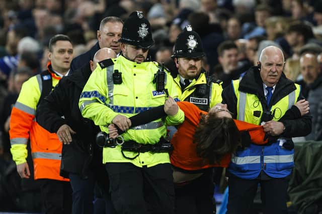 McKechnie is carried from the pitch by police