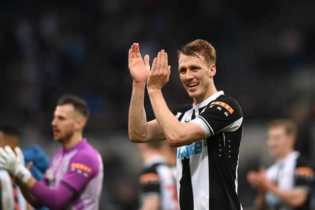 Dan Burn applauds Newcastle United fans at St James's Park.