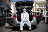 Uber driver Yasar Gorur wears personal protective equipment while cleaning his vehicle (Photo: Hollie Adams/Getty Images)