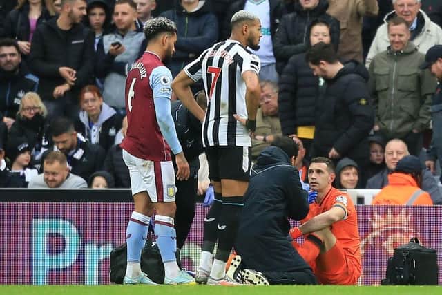 Aston Villa's Argentinian goalkeeper Emiliano Martinez (R) receives medical attention after suffering a knock during the English Premier League football match between Newcastle United and Aston Villa at St James' Park in Newcastle-upon-Tyne, north east England on October 29, 2022.  (Photo by LINDSEY PARNABY/AFP via Getty Images)