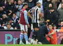 Aston Villa's Argentinian goalkeeper Emiliano Martinez (R) receives medical attention after suffering a knock during the English Premier League football match between Newcastle United and Aston Villa at St James' Park in Newcastle-upon-Tyne, north east England on October 29, 2022.  (Photo by LINDSEY PARNABY/AFP via Getty Images)