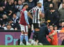 Aston Villa's Argentinian goalkeeper Emiliano Martinez (R) receives medical attention after suffering a knock during the English Premier League football match between Newcastle United and Aston Villa at St James' Park in Newcastle-upon-Tyne, north east England on October 29, 2022.  (Photo by LINDSEY PARNABY/AFP via Getty Images)