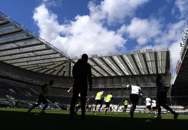 NEWCASTLE UPON TYNE, ENGLAND - JULY 05: General view inside the stadium as the Newcastle United players warm up prior to the Premier League match between Newcastle United and West Ham United at St. James Park on July 05, 2020 in Newcastle upon Tyne, England. Football Stadiums around Europe remain empty due to the Coronavirus Pandemic as Government social distancing laws prohibit fans inside venues resulting in games being played behind closed doors. (Photo by Michael Regan/Getty Images)