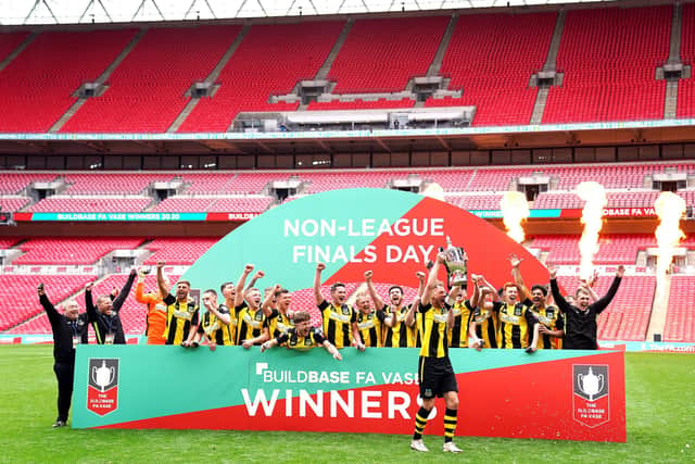 Hebburn Town's Louis Storey celebrates with team-mates and staff with the Buildbase FA Vase 2019/20 Trophy after victory in the Final at Wembley Stadium, London.