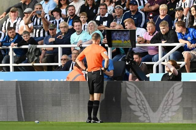 Referee Jarred Gillett checks the VAR screen of the red card given to Kieran Trippier of Newcastle United which is overturned to a yellow card during the Premier League match between Newcastle United and Manchester City at St. James Park on August 21, 2022 in Newcastle upon Tyne, England. (Photo by Stu Forster/Getty Images)