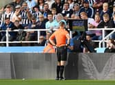 Referee Jarred Gillett checks the VAR screen of the red card given to Kieran Trippier of Newcastle United which is overturned to a yellow card during the Premier League match between Newcastle United and Manchester City at St. James Park on August 21, 2022 in Newcastle upon Tyne, England. (Photo by Stu Forster/Getty Images)