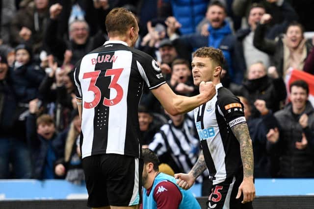 Newcastle United's English defender Kieran Trippier (R) celebrates with Newcastle United's English defender Dan Burn (L) after scoring the opening goal during the English Premier League football match between Newcastle United and Aston Villa at St James' Park in Newcastle-upon-Tyne, north east England on February 13, 2022. (Photo by OLI SCARFF/AFP via Getty Images)