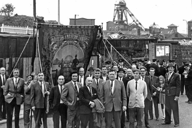 The banner of Harton and Westoe Miners' Lodge hangs high outside the empty buildings of Harton Colliery, closed almost a year earlier, in 1970.  Lodge officials and members were on their way to the Durham Miners Gala.