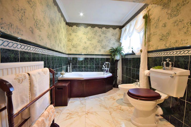 Ornate bath with handheld mixer shower, porcelain bidet, low-flush WC, hand wash basin and full tiled underfloor heating.