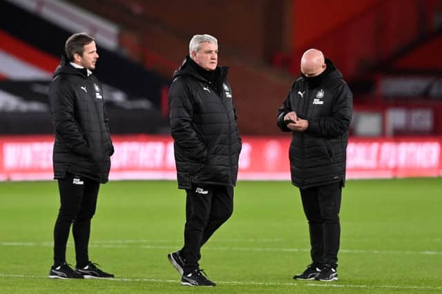 Newcastle United's English head coach Steve Bruce (C) and Assistant Coaches Stephen Clemence (L) and Steve Agnew (R) walk on the pitch ahead of the English Premier League football match between Sheffield United and Newcastle United at Bramall Lane in Sheffield, northern England on January 12, 2021.