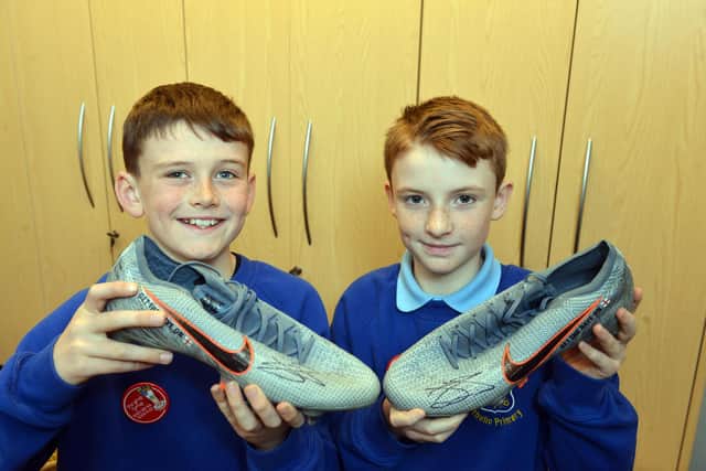 SS Peter and Paul Catholic Primary School are to raffle Jordan Pickford's boots as part of the Christmas appeal. Pupils from left Jack Moss, 10 and Katie Newton, 10.