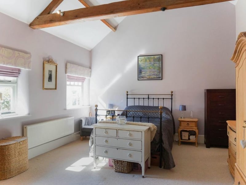 Master bedroom featuring vaulted ceiling and original exposed oak beams with 4 piece ensuite bathroom with underfloor heating.