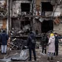 People look at the exterior of a damaged residential block hit by an early morning missile strike in Kyiv, Ukraine. Picture: Chris McGrath/Getty Images.