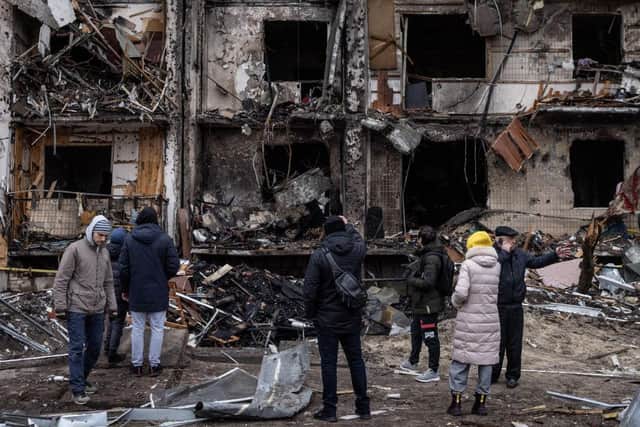People look at the exterior of a damaged residential block hit by an early morning missile strike in Kyiv, Ukraine. Picture: Chris McGrath/Getty Images.
