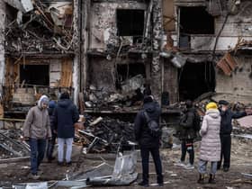 People look at the exterior of a damaged residential block hit by an early morning missile strike in Kyiv, Ukraine. Picture: Chris McGrath/Getty Images.