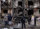 People look at the exterior of a damaged residential block hit by an early morning missile strike in Kyiv, Ukraine. Picture: Chris McGrath/Getty Images.