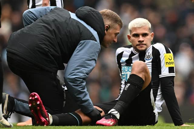 Newcastle United midfielder Bruno Guimaraes is treated by medical staff.