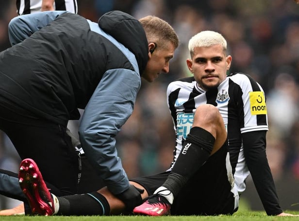 Newcastle United midfielder Bruno Guimaraes is treated by medical staff.