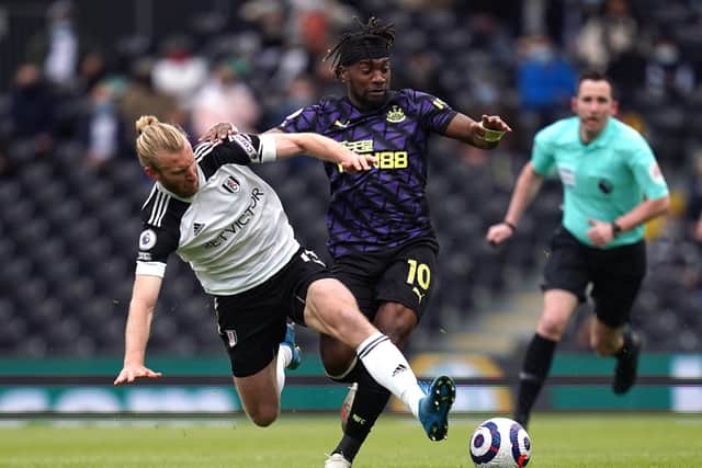 Fulham's Tim Ream (left) and Newcastle United's Allan Saint-Maximin (right) battle for the ball during the Premier League match at Craven Cottage, London. Picture date: Sunday May 23, 2021.
