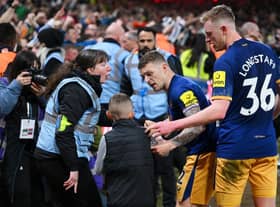 Kieran Trippier and Sean Longstaff of Newcastle United speak to a steward and a young fan after the Premier League match between Nottingham Forest and Newcastle United at City Ground on March 17, 2023 in Nottingham, England. (Photo by Laurence Griffiths/Getty Images)