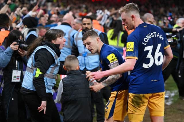 Kieran Trippier and Sean Longstaff of Newcastle United speak to a steward and a young fan after the Premier League match between Nottingham Forest and Newcastle United at City Ground on March 17, 2023 in Nottingham, England. (Photo by Laurence Griffiths/Getty Images)