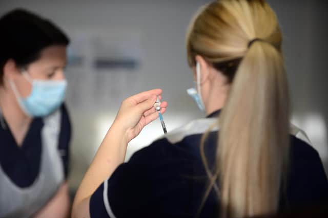 Health workers prepare covid vaccines.