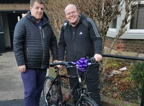 Andrew receiving his new bike from Matthew