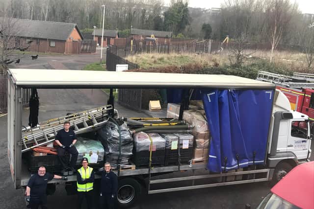 Staff at Tony Carter Transport Limited loading fire equipment onto lorry at TWFRS Stores warehouse