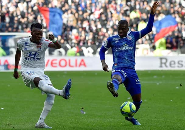 Lyon's Burkinabe forward Bertrand Traore (L) fights for the ball with Strasbourg's Ivorian forward Kevin Zohi (R) during the French L1 football match between Lyon (OL) and Strasbourg (RCSA) on February 16, 2020 at the Groupama Stadium in Decines-Charpieu near Lyon, southeastern France. (Photo by JEAN-PHILIPPE KSIAZEK / AFP) (Photo by JEAN-PHILIPPE KSIAZEK/AFP via Getty Images)