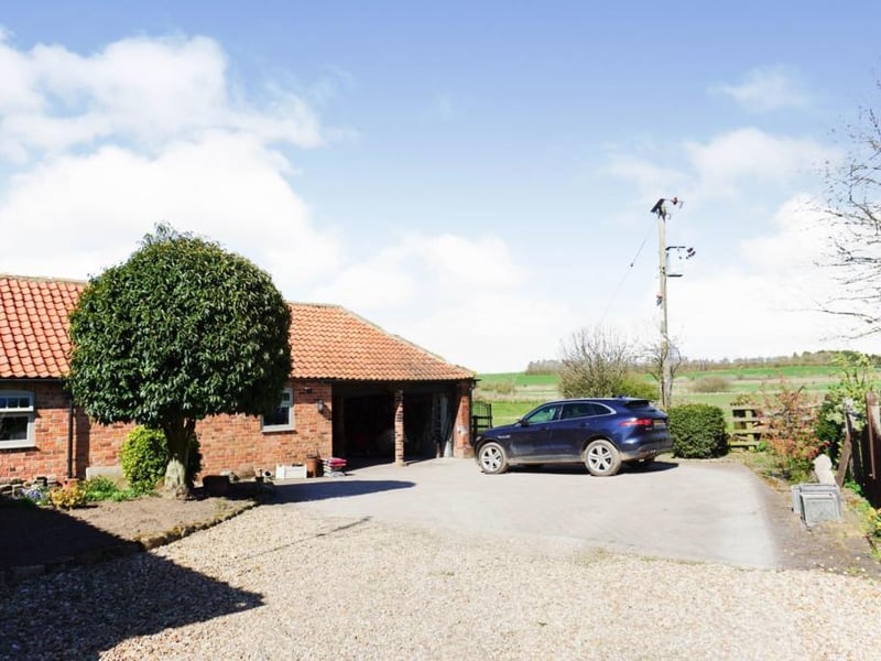 Double garage with with electric operated roller door, feature brick pillars, built in cupboards and door to utility room.