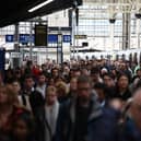 Commuters walk along a packed platform after a single train arrived during the morning rush hour, at Waterloo Station in London on April 8, 2024, as train drivers strike over pay. (Photo by HENRY NICHOLLS / AFP)