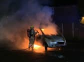 Firefighters attend the scene of a car fire.