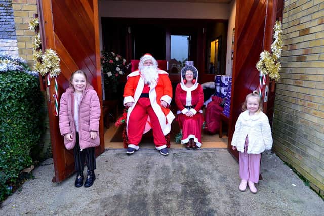 Maisie (left) and Charlotte Harwood with Santa and Mrs Claus. Picture by Frank Reid