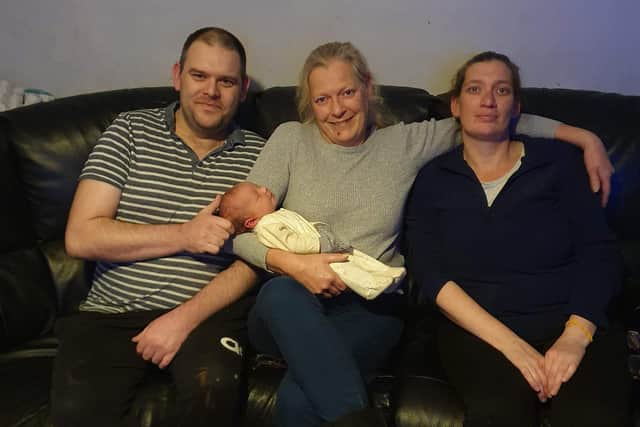 Dawn holding baby Roman with her daughter Lynsay and partner James.