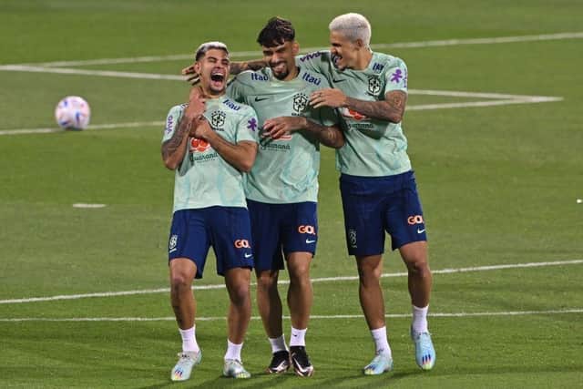 Brazil's midfielders Bruno Guimaraes (L) and Lucas Paqueta and forward Pedro laugh during a training session at the Al Arabi SC Stadium in Doha on November 20, 2022, just moments before the kick-off of the Qatar 2022 World Cup football tournament. (Photo by NELSON ALMEIDA/AFP via Getty Images)