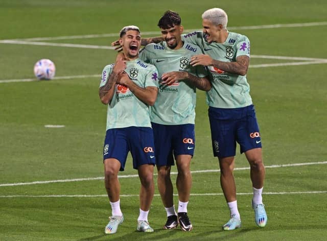 Brazil's midfielders Bruno Guimaraes (L) and Lucas Paqueta and forward Pedro laugh during a training session at the Al Arabi SC Stadium in Doha on November 20, 2022, just moments before the kick-off of the Qatar 2022 World Cup football tournament. (Photo by NELSON ALMEIDA/AFP via Getty Images)