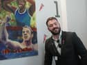 Josef Craig MBE in front of his artistic drawing by student