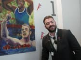 Josef Craig MBE in front of his artistic drawing by student