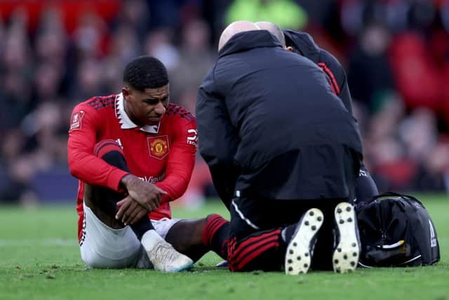 Marcus Rashford of Manchester United receives medical treatment during the Emirates FA Cup Quarter Final match between Manchester United and Fulham at Old Trafford on March 19, 2023 in Manchester, England. (Photo by Clive Brunskill/Getty Images)