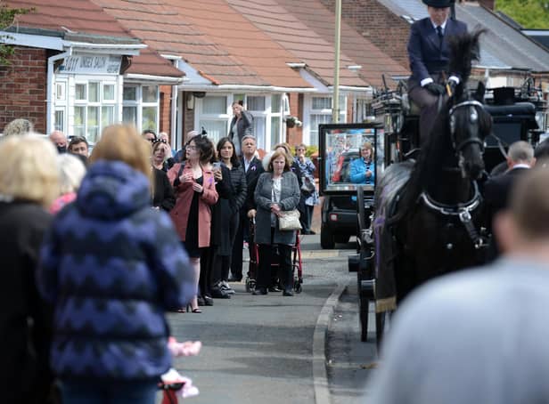 Funeral procession for Monkton Village store Gladys Stonehouse as mourners gather on the street.