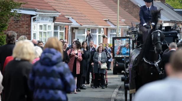 Funeral procession for Monkton Village store Gladys Stonehouse as mourners gather on the street.