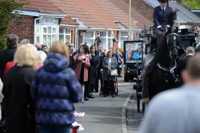 Funeral procession for Monkton Village store Gladys Stonehouse as mourners gather on the street.